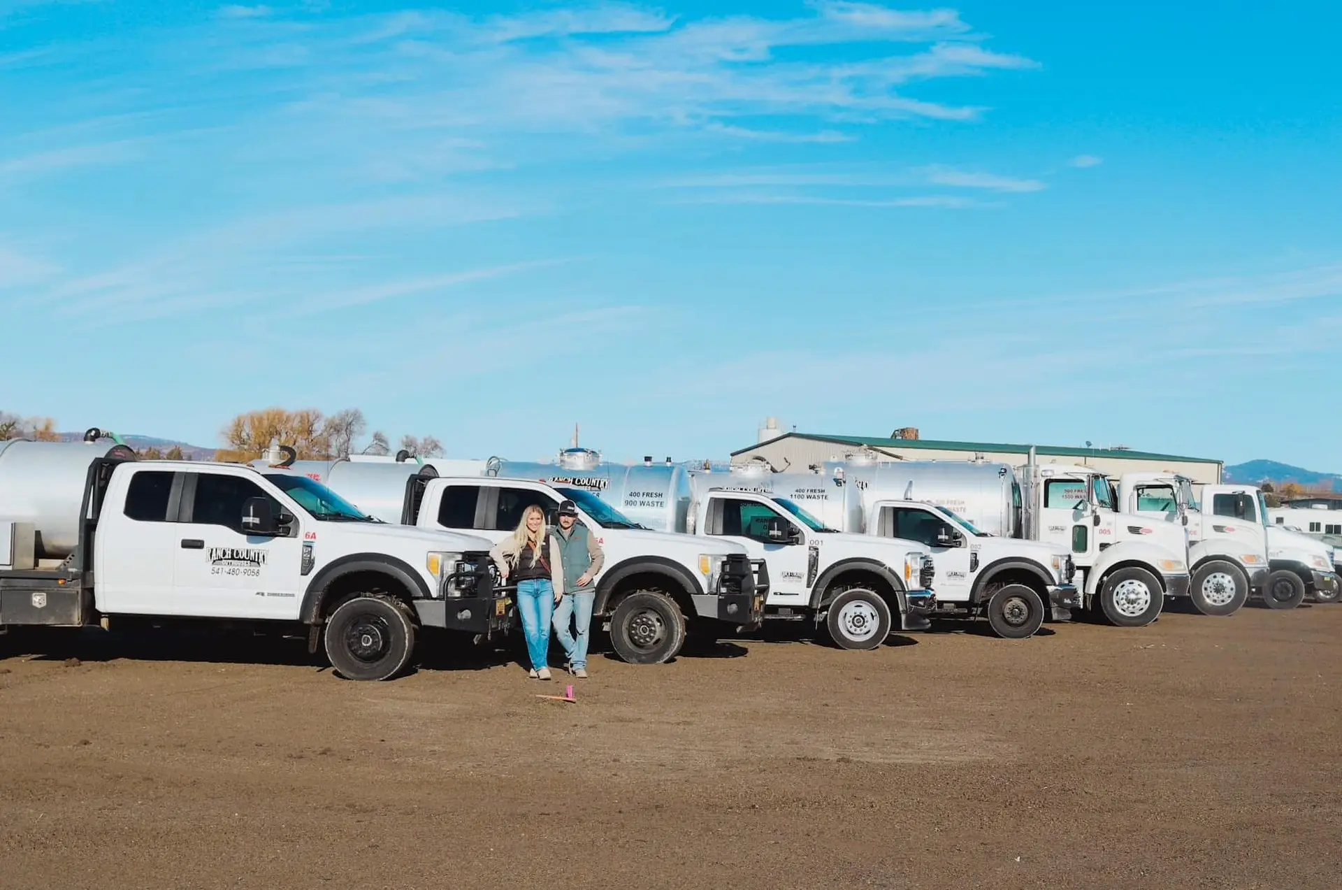 The Ranch Country Outhouses crew standing with their fleet of septic pump trucks in Central Oregon
